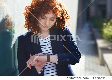Woman in city, checking time and smartwatch on wrist on morning commute to work or appointment. Street, schedule and businesswoman looking at watch on urban sidewalk before job interview or meeting. 132829433
