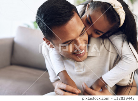 Family, hug and girl with father on sofa, happy and laugh, kiss and bonding in their home. Embrace, smile and parent with child on couch, play or enjoy day off, weekend or piggyback in a living room 132829442