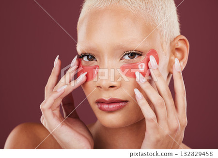 Portrait, eye mask and antiaging with a model black woman in studio on a red background for skincare. Face, skin and beauty with an attractive young female posing to promote a cosmetic product Portrait, eye mask and antiaging with a model black woman in studio on a red background for skincare. Face, skin and beauty with an attractive young female posing to promote a cosmetic product 132829458