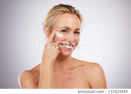 Portrait, skincare and lotion with a mature woman in studio on a gray background for antiaging beauty treatment. Face, product and cream with an attractive female in the bathroom to apply moisturizer Portrait, skincare and lotion with a mature woman in studio on a gray background for antiaging beauty treatment. Face, product and cream with an attractive female in the bathroom to apply moisturizer 132829480