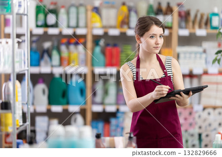 Young woman seller conducting inventory with tablet 132829666