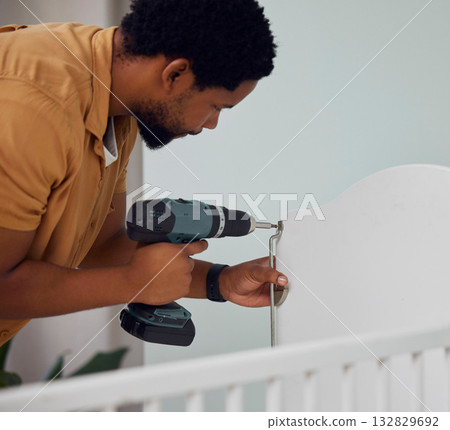 Installation, drill and man building a crib while preparing for his new baby in the family home. Engineering, metal and African father doing maintenance or repairs on the bed in nursery at his house. 132829692