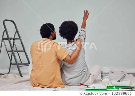 Painting, wall or black couple planning DIY, home renovation or house remodel together on floor. Back view, pointing or African man loves speaking to young woman working with teamwork in partnership 132829695