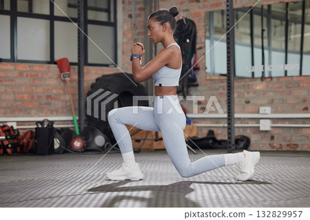 Fitness, exercise and profile of a woman doing lunges at gym for health and wellness training workout. Indian athlete person focus with commitment to train strong body, energy and muscle for power 132829957