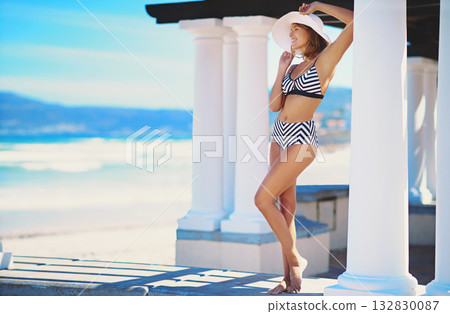 Woman, bikini and beach for holiday with space by pillar for mockup, happiness and fashion in summer. Girl, swimsuit and smile for carefee freedom in sunshine by ocean on vacation, relax and mock up Woman, bikini and beach for holiday with space by pillar for mockup, happiness and fashion in summer. Girl, swimsuit and smile for carefee freedom in sunshine by ocean on vacation, relax and mock up 132830087