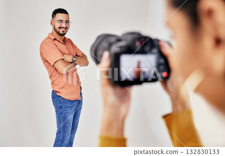 Shooting, photography and photographer with man model in studio for creative, advertising and image. Media, backstage and professional woman videographer with guy, camera and equipment for photoshoot 132830133