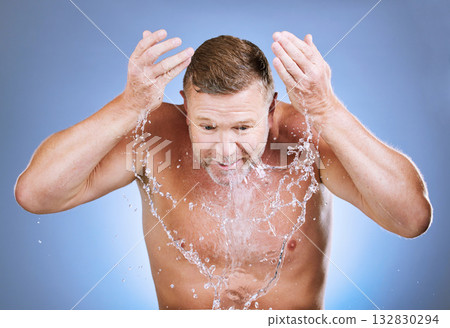 Man, water splash and cleaning face for skincare, wellness shower or blue background. Mature model, male beauty and clean facial for aesthetic, healthy glow and morning dermatology on studio backdrop Man, water splash and cleaning face for skincare, wellness shower or blue background. Mature model, male beauty and clean facial for aesthetic, healthy glow and morning dermatology on studio backdrop 132830294