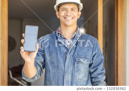 Construction worker, man in portrait and smartphone, screen with mockup and contact, digital marketing and handyman. Home renovation, maintenance and industry trade, promo with product placement 132830362