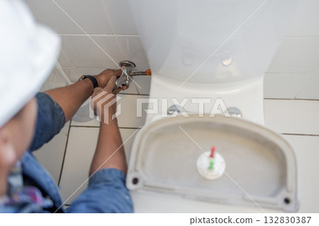 Toilet maintenance, plumber hands and wrench fix of a renovation employee in the bathroom. Home improvement, development and house repair of industrial pipe and construction worker doing a job Toilet maintenance, plumber hands and wrench fix of a renovation employee in the bathroom. Home improvement, development and house repair of industrial pipe and construction worker doing a job 132830387