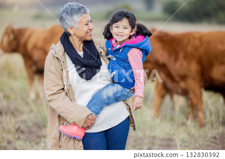 Grandmother, happy girl portrait and nature with cows and senior woman in the countryside. Outdoor field, hug and elderly female with child on a family adventure on vacation with happiness and fun Grandmother, happy girl portrait and nature with cows and senior woman in the countryside. Outdoor field, hug and elderly female with child on a family adventure on vacation with happiness and fun 132830392