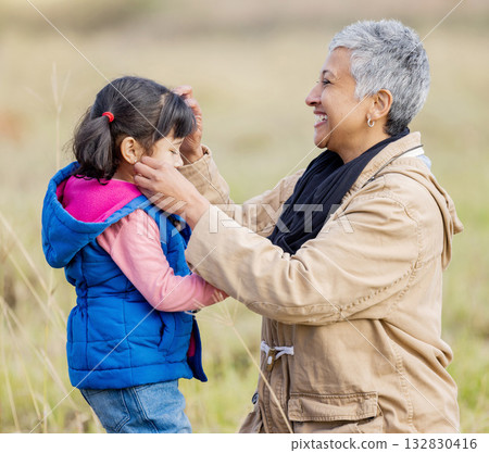 Happy grandmother, young girl and nature walk on farm with senior woman in the countryside. Outdoor field, grass and elderly female with child on family adventure on vacation with happiness and fun Happy grandmother, young girl and nature walk on farm with senior woman in the countryside. Outdoor field, grass and elderly female with child on family adventure on vacation with happiness and fun 132830416