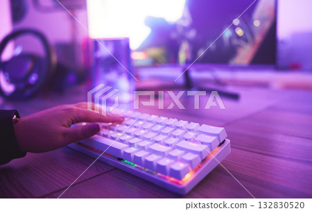 PC keyboard, gaming and hand for video game, online streaming and gamer room in neon light. Woman or person hands typing or press keys on gamer electronics, computer technology and rgb lights closeup PC keyboard, gaming and hand for video game, online streaming and gamer room in neon light. Woman or person hands typing or press keys on gamer electronics, computer technology and rgb lights closeup 132830520