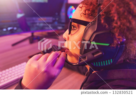 Video game, girl and talking on headphones in home for esports, online games and virtual competition. Female gamer, computer live streaming and gaming in neon lighting, technology and gen z streamer 132830521