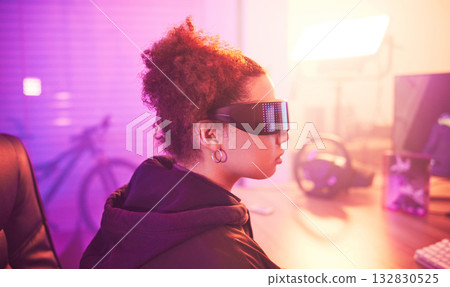 Metaverse, virtual reality glasses and woman gamer for futuristic gaming in purple room. Cyberpunk person with ar tech for 3d, vr and cyber world experience streaming online digital fantasy game 132830525