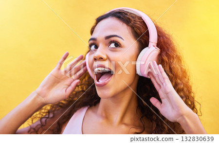 Music, freedom and wow with a black woman listening to the radio outdoor on a yellow wall background. Headphones, energy and face with an attractive young female streaming audio sound for fun Music, freedom and wow with a black woman listening to the radio outdoor on a yellow wall background. Headphones, energy and face with an attractive young female streaming audio sound for fun 132830639