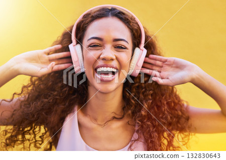 Music, portrait and freedom with a black woman listening to the radio outdoor on a yellow wall background. Headphones, energy and face with an attractive young female streaming audio sound for fun Music, portrait and freedom with a black woman listening to the radio outdoor on a yellow wall background. Headphones, energy and face with an attractive young female streaming audio sound for fun 132830643