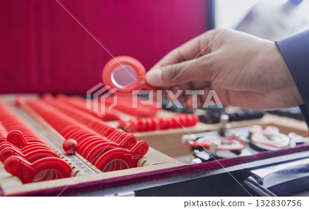 Trial lens, optometry and vision test, ophthalmologist hand and tools, eye care and frame with health. Glasses, healthcare for eyes and person in clinic with exam equipment and expert with eyewear 132830756