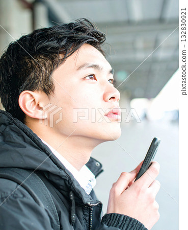 A young man thinking with a smartphone in his hand A young man thinking with a smartphone in his hand 132830921