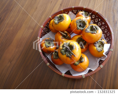 A basket filled with persimmons A basket filled with persimmons 132831325