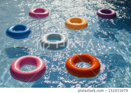 Colorful Pool Rings Floating Playfully in Clear Water Under Bright Sunlight Colorful Pool Rings Floating Playfully in Clear Water Under Bright Sunlight 132831678