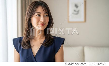 Portrait of a woman smiling gently in a bright living room 132832428