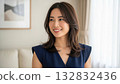 Portrait of a woman smiling toothily in a bright living room 132832436