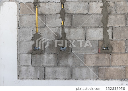 Worker is marking lebel for electrical outlets and wall switches location on new kitchen wall. 132832958