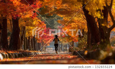 一個人沿著鋪滿秋葉的道路奔跑。 132833224