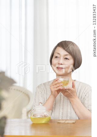 夏天，一位老婦人在客廳喝冰茶。 132833437