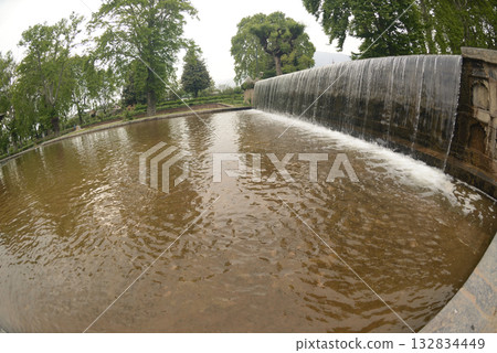 The buildings and ponds that decorate the Shalimar Bagh Gardens are a beautiful Mughal garden in Srinagar, Jammu and Kashmir, India. The gardens are decorated with fountains, ponds and plants. The buildings and ponds that decorate the Shalimar Bagh Gardens are a beautiful Mughal garden in Srinagar, Jammu and Kashmir, India. The gardens are decorated with fountains, ponds and plants. 132834449