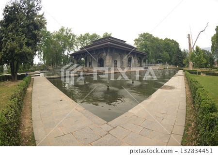 The buildings and ponds that decorate the Shalimar Bagh Gardens are a beautiful Mughal garden in Srinagar, Jammu and Kashmir, India. The gardens are decorated with fountains, ponds and plants. The buildings and ponds that decorate the Shalimar Bagh Gardens are a beautiful Mughal garden in Srinagar, Jammu and Kashmir, India. The gardens are decorated with fountains, ponds and plants. 132834451