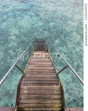 Wooden stairs leading to the clear sea 132834453