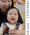 Smiling baby being held by mom 132834680