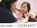 Baby playing with mom 132834957