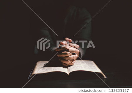 Hands folded in prayer on the Holy Bible, symbolizing faith, devotion, Christianity, hope, and spiritual strength. Concept of worship, meditation and trusting God Word. Hands folded in prayer on the Holy Bible, symbolizing faith, devotion, Christianity, hope, and spiritual strength. Concept of worship, meditation and trusting God Word. 132835157