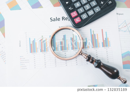 Magnifying glass with calculator and pen on financial reports with charts, graphs at office desk. Concept of business analysis, accounting audit, financial accuracy, transparency, corporate strategy. Magnifying glass with calculator and pen on financial reports with charts, graphs at office desk. Concept of business analysis, accounting audit, financial accuracy, transparency, corporate strategy. 132835189