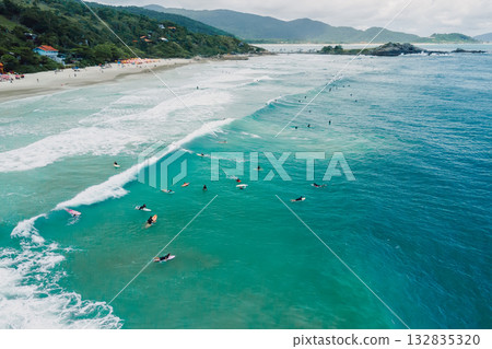 Surfers on surfboards in ocean waiting wave in Floripa. Aerial view in Brazil Surfers on surfboards in ocean waiting wave in Floripa. Aerial view in Brazil 132835320