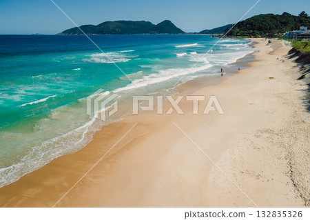 Beach and blue ocean with waves in Brazil. Aerial view of Morro das Pedras Beach and blue ocean with waves in Brazil. Aerial view of Morro das Pedras 132835326
