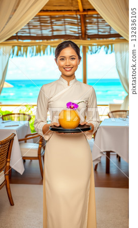 Beautiful Asian woman waiter carrying on tray drinks while working in restaurant. 132836105