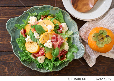 Autumnal salad of persimmon, prosciutto and cottage cheese Autumnal salad of persimmon, prosciutto and cottage cheese 132836229