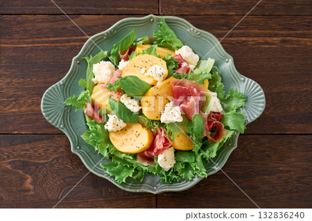 Autumnal salad of persimmon, prosciutto and cottage cheese 132836240