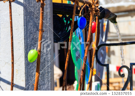 Colorful painted decorative Easter eggs hanging by an iron frame outside Colorful painted decorative Easter eggs hanging by an iron frame outside 132837055