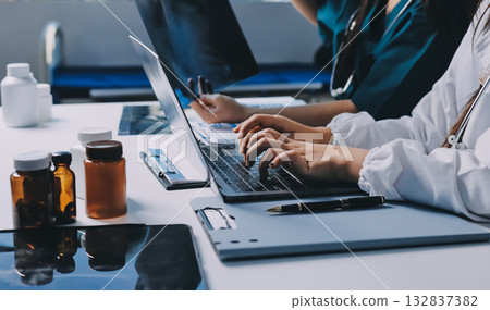 Group of doctors attending seminar in hospital lecture hall with senior physician giving medical presentation and professional training session on healthcare practices Group of doctors attending seminar in hospital lecture hall with senior physician giving medical presentation and professional training session on healthcare practices 132837382