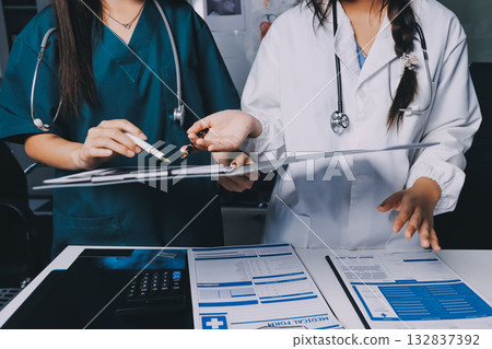 Group of doctors attending seminar in hospital lecture hall with senior physician giving medical presentation and professional training session on healthcare practices 132837392