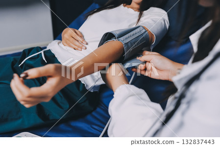 Nurse measuring blood pressure of elderly woman at table, closeup. Assisting senior generation 132837443