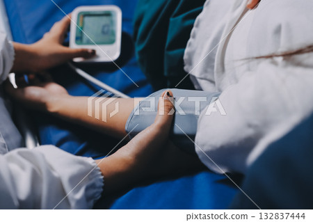 Nurse measuring blood pressure of elderly woman at table, closeup. Assisting senior generation 132837444