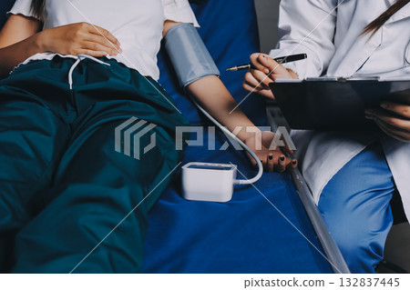 Nurse measuring blood pressure of elderly woman at table, closeup. Assisting senior generation Nurse measuring blood pressure of elderly woman at table, closeup. Assisting senior generation 132837445