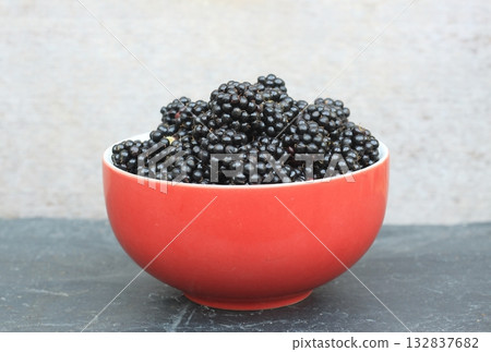 Sweet ripe blackberries, lat. Rubus fruticosus Thornless in a red bowl. 132837682