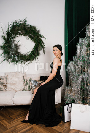 Woman Sitting by Festive Christmas Decor Woman Sitting by Festive Christmas Decor 132838022