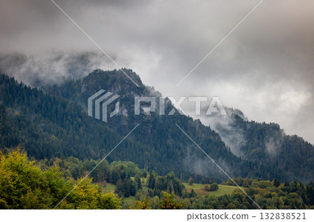 Misty mountain landscape with lush green forests and towering peaks shrouded in clouds creating a serene and atmospheric view. The Mala Fatra national park in Slovakia, Europe. 132838521